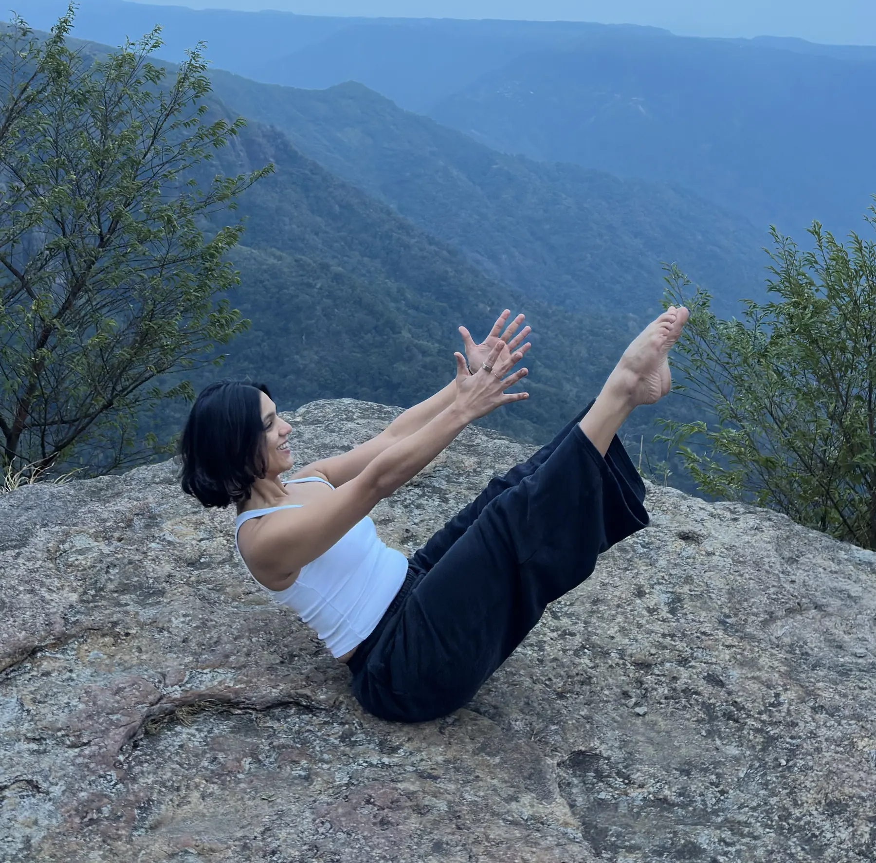 Pilates teaser on a rock above a misty valley